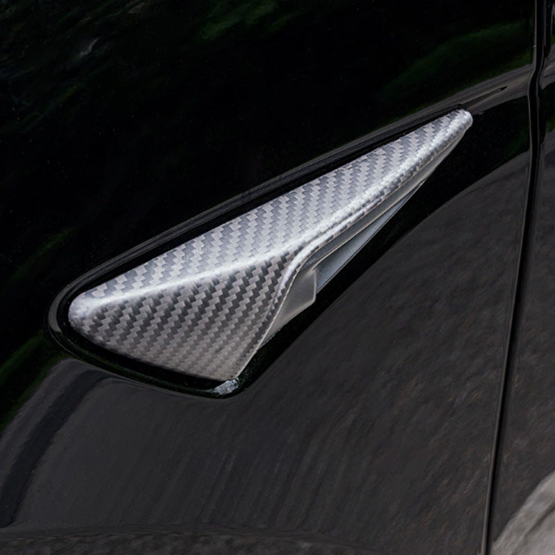 Carbon fiber camera cover installed, adding a sporty exterior accent.